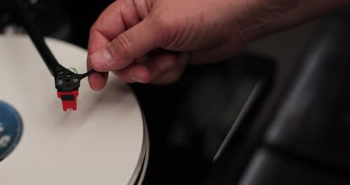 Hand Places Needle on Rotating Record Player