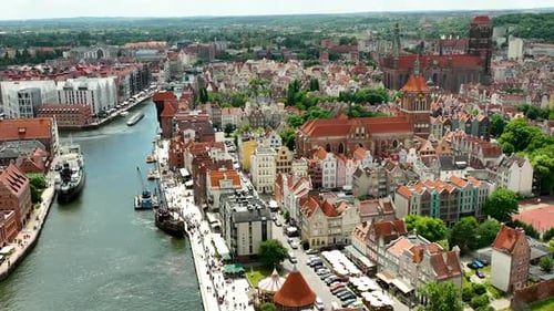 Aerial Gdańsk's old town, focusing on the dense cluster of historic buildings and churches. The arch