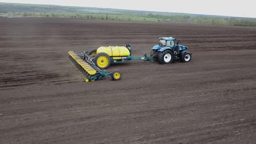 Blue tractor OA working on the field in Ukraine