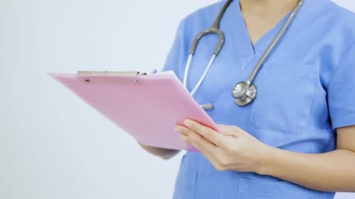 Close-up video of an Asian female nurse prescribing medication.