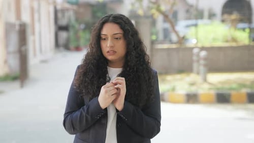 Worried Young Woman Standing Still in an Urban Area