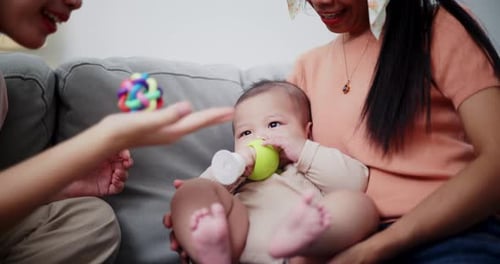 Baby with Family Plays with Colorful Toys