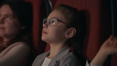 Girl In Glasses Watching Cartoon Film At Movie Theater. Girl Smiling In Movie Theatre. Cinema Kid...