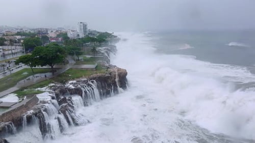 Natural catastrophe with crashing waves of ocean flooding city during stormy hurricane. Aerial birds