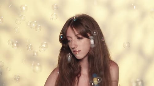 Appealing Brunette Girl Looks Stressed By Many Small Soap Bubbles Flying Around Her Slow Motion