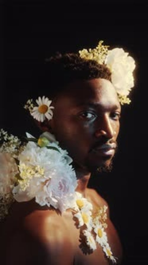 Studio Portrait of Young Black Man Adorned with Flowers
