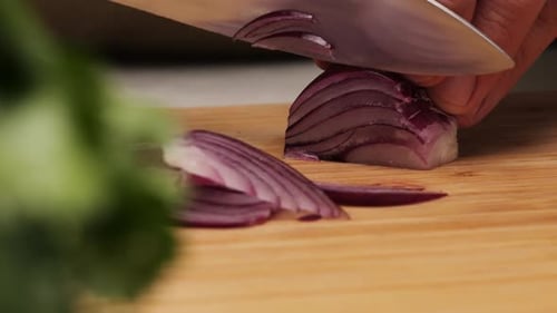 Cutting Red Onion on Cutting Board with Knife