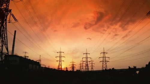 Red sunrise with power lines. Hydro transmission lines and towers making up the electricity grid.