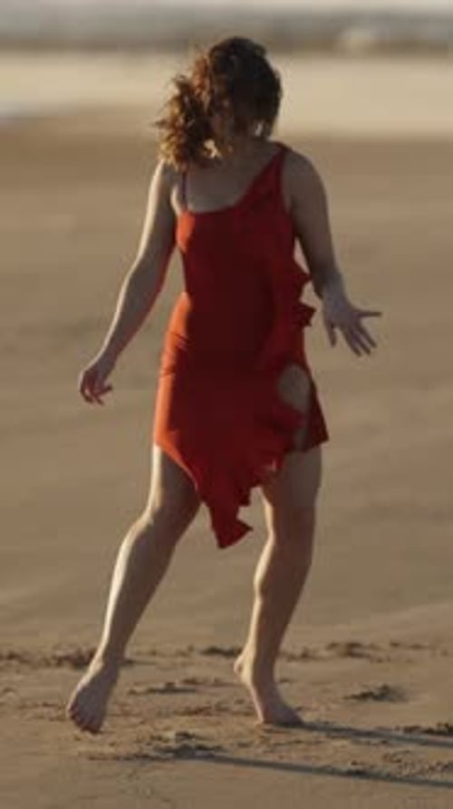 Woman Dancing on the Beach in Red Dress