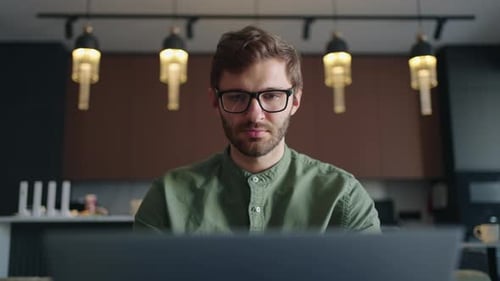 Porträt eines Mannes mit Brille, der zu Hause per Laptop im Internet surft und Suchabfrage im Browser eingibt
