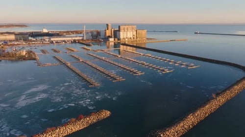 El paseo marítimo industrial y el puerto deportivo de Port Colborne al atardecer, aguas tranquilas, vista aérea