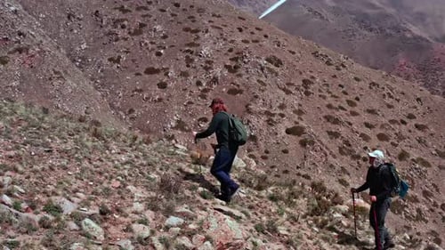 Two climbers are walking in mountain peak together outdoors, stunning rocky landscape