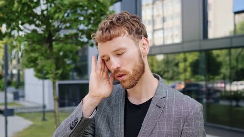 Man with Headache Touching Temple Outside