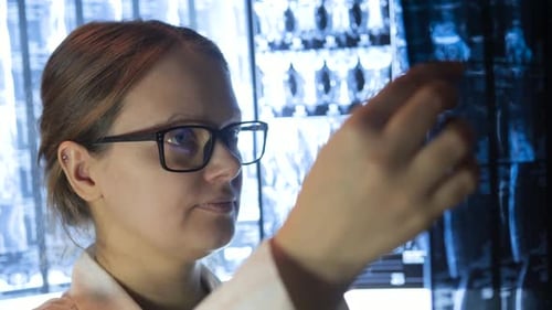 Ärztin mit Brille liest Röntgenbilder aus nächster Nähe