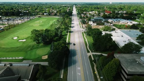 Aerial drone top shot over a long highway with cars passing by beside the Golf club in Northbrook Il
