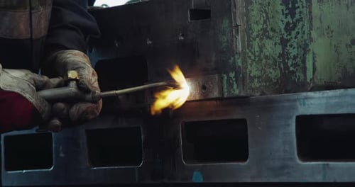 Worker using a soldering iron to weld in an industrial workshop