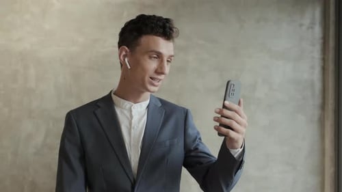 Young Man Video Calling on Smartphone Indoors