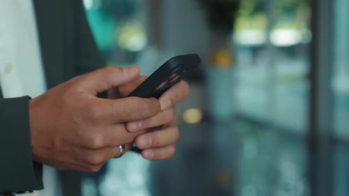 Young Businessman Hands Write Message on Smartphone in Corporate Office