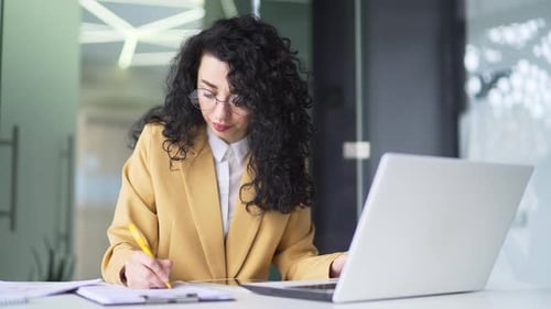 Young Woman Works at Laptop in Modern Office