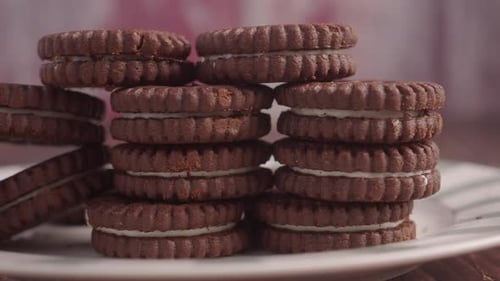 Chocolate Sandwich Cookies with Cream Filling Stacked on Plate