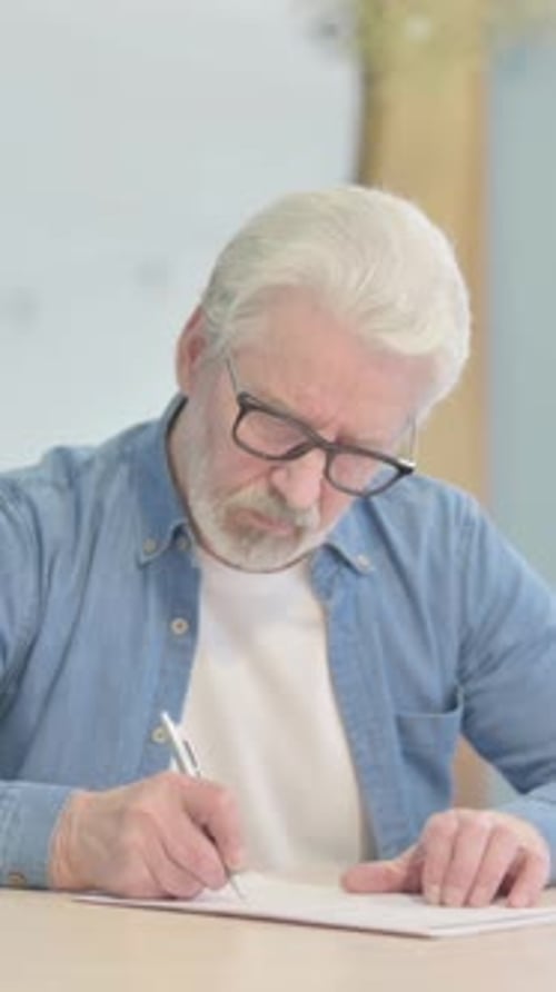Old Man Writing Letter in Office, vertical video