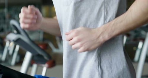 A guy in the gym to stay fit and have defined muscles or lose weight runs on the treadmill with a