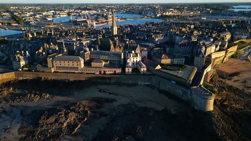 Outside of Saint Malo Intra Muros coastal shoreline during low tide at sunset, Saint-Malo, France. A