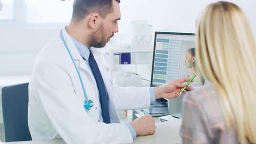 Plastic / Cosmetic Surgeon Consults Woman about Facial Lift Surgery, He Points at Computer Screen S