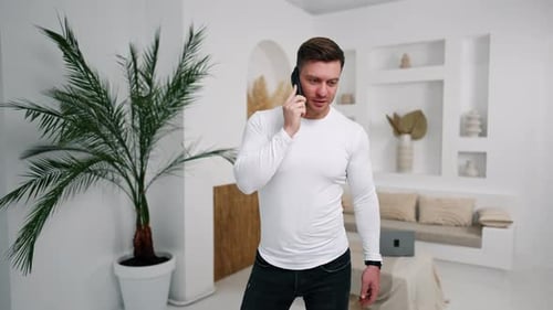Young Adult Man Talking on Smartphone Indoors