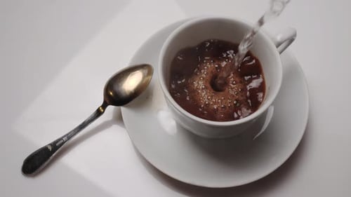 Pouring Hot Water into Cup of Coffee