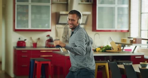 Happy Man Dancing in Modern Red Kitchen