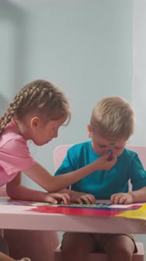 Girl Drawing with Boy at Pink Table