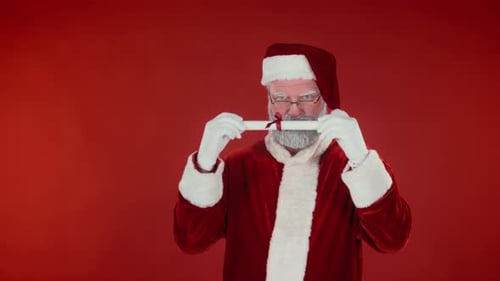 Santa Claus Unties Scroll on Red Background