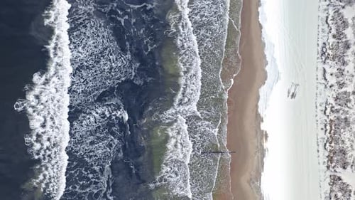 Man on snowy beach in winter at Baltic sea, Poland