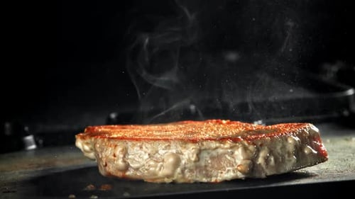 A Sizzling Macro Cinematic Close Up Of Thick Steak Grilling In Pan