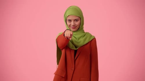 Mittelgroßes, isoliertes Video, das eine attraktive junge Frau zeigt, die einen Hijab-Schleier trägt, auf den sie zeigt