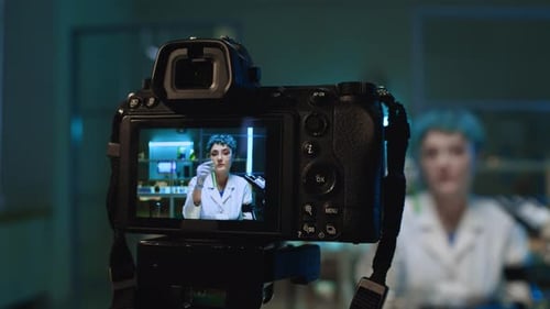 Scientist on Camera Holding Vial in Lab
