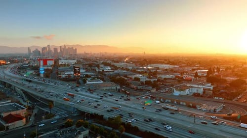 Wide multi-lane highway with numerous cars moving to and from downtown.