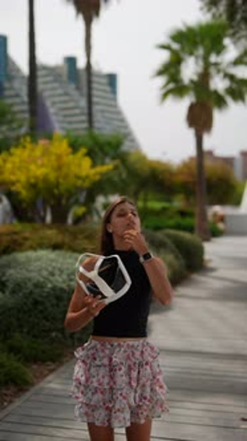 Young Woman Holds VR Goggles in Urban Park