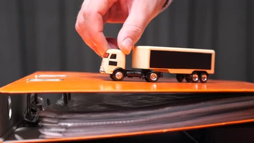 Toy Truck on Orange Binder in Office Setting