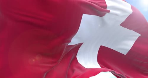 Realistic Waving Flag of Switzerland Against Blue Sky