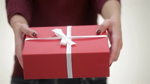 Woman Holding Red Gift Box with White Ribbon