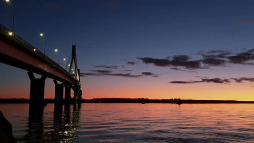 Low static view of bridge over water at beautiful colorful sunset