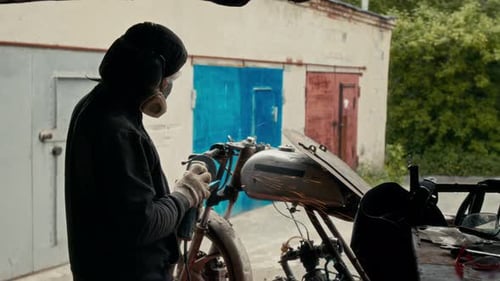 Hombre irreconocible que usa una máquina de soldar en su motocicleta hecha a medida