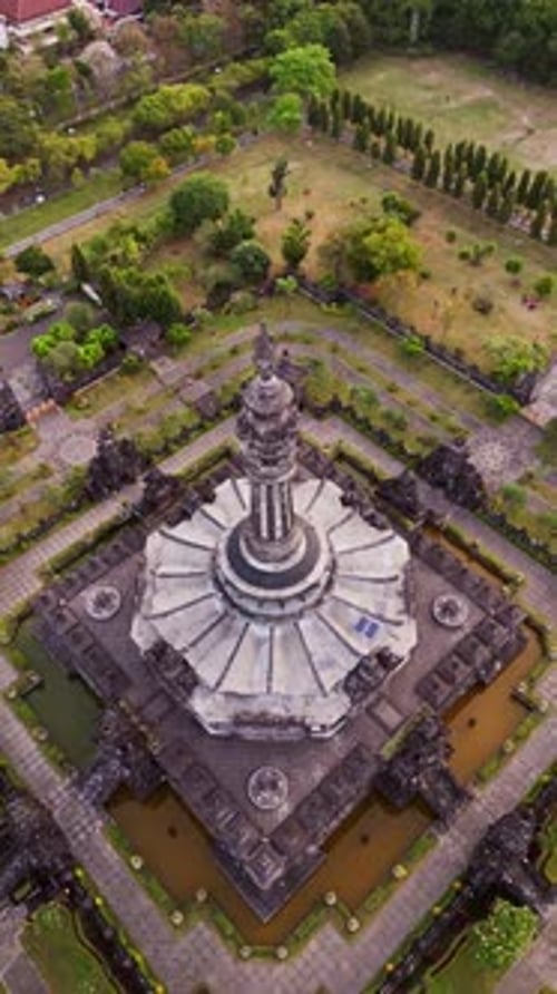 Capture verticale par drone du monument de Bajra Sandhi qui surplombe la paisible verdure urbaine de Denpasar
