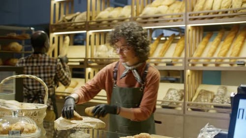 Diverse Bakery Workers Arranging Fresh Pastries and Bread on Display for Sale