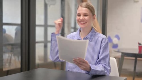 Woman Celebrates Reading Good News in Office