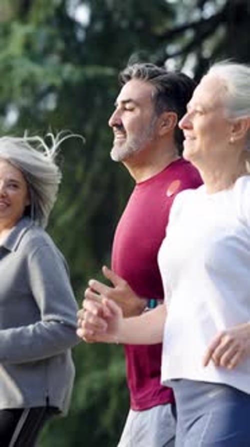 Group of Mature People Running Outdoors in a Park Vertical