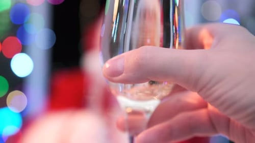 Papai Noel tilintando taças de champanhe com uma jovem, de perto, na festa de Natal