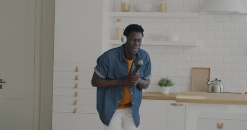 Man Singing and Dancing in Kitchen with Spatula